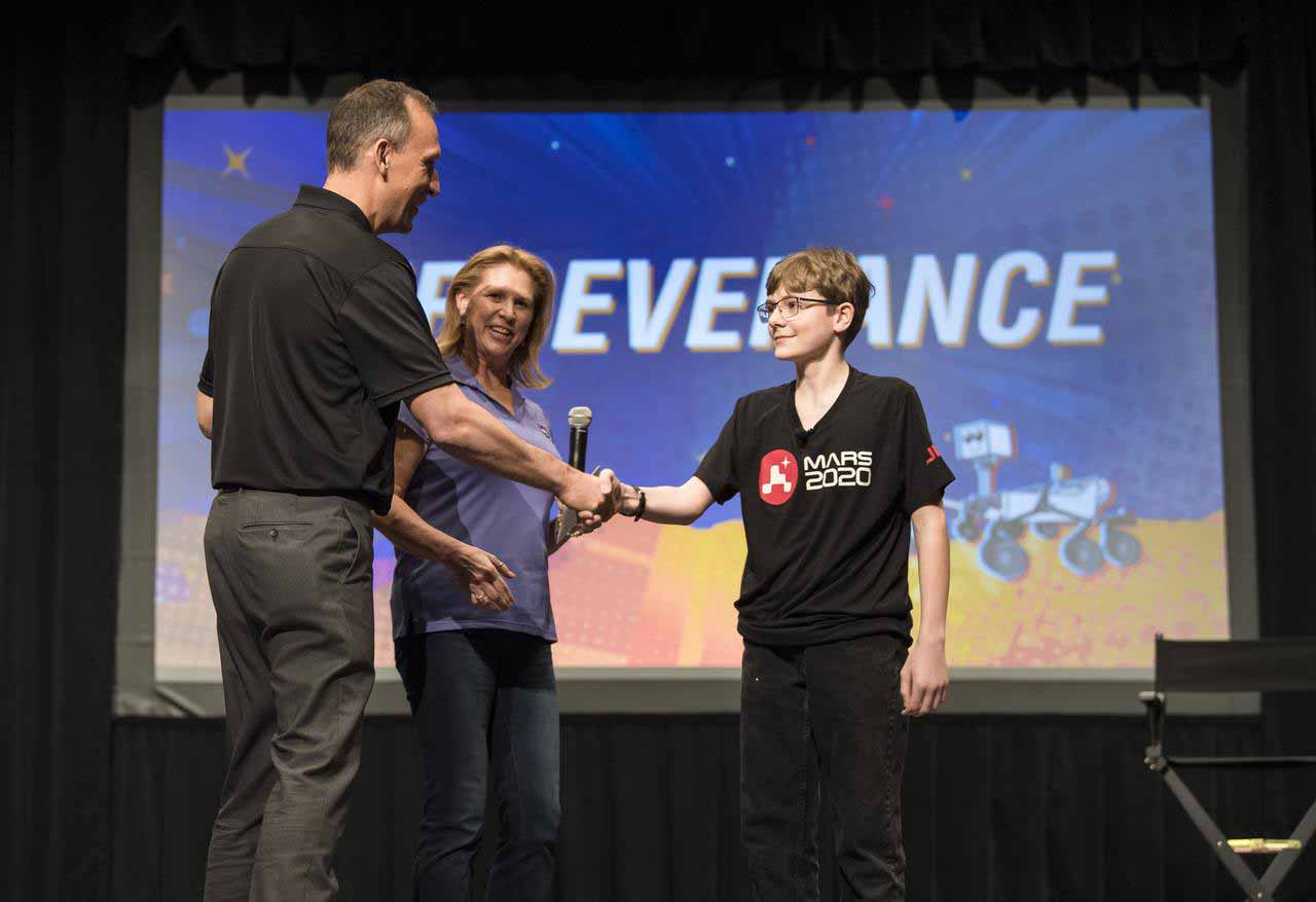 Thomas Zurbuchen gratuliert Alex Mather zu seinem Sieg in einem Schulwettbewerb. © NASA/Aubrey Gemignani
